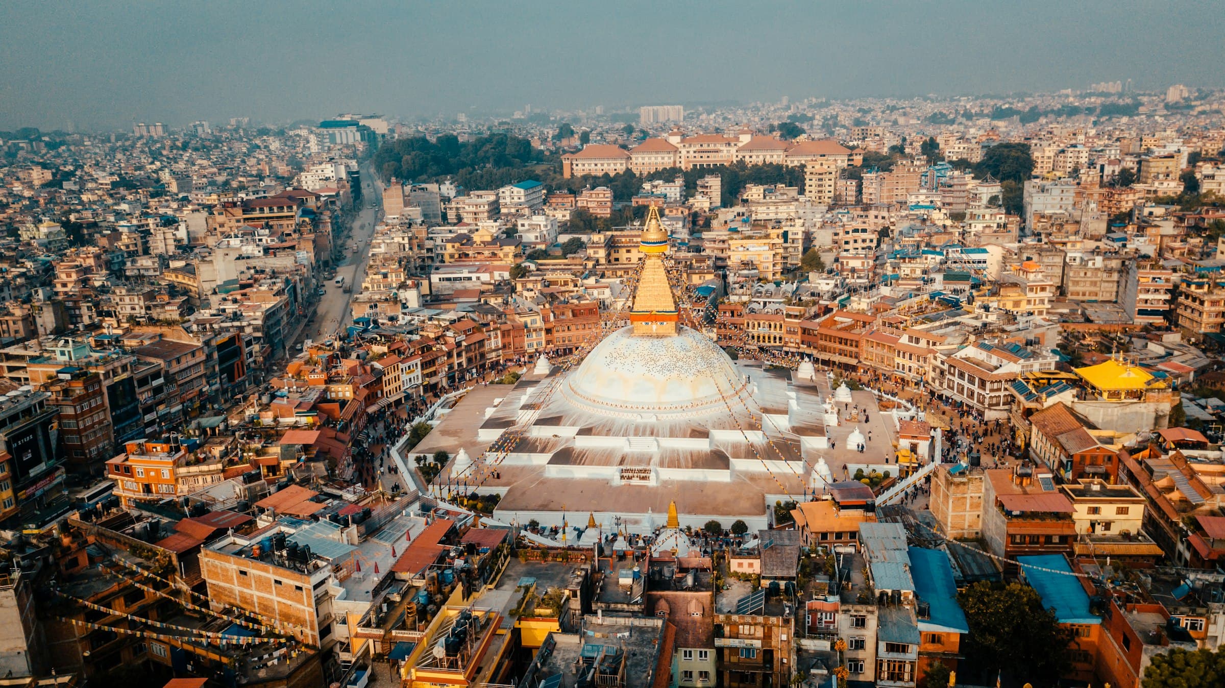 Aerial view of the white dome of Boudhanath stupa amid Kathmandu's rooftops