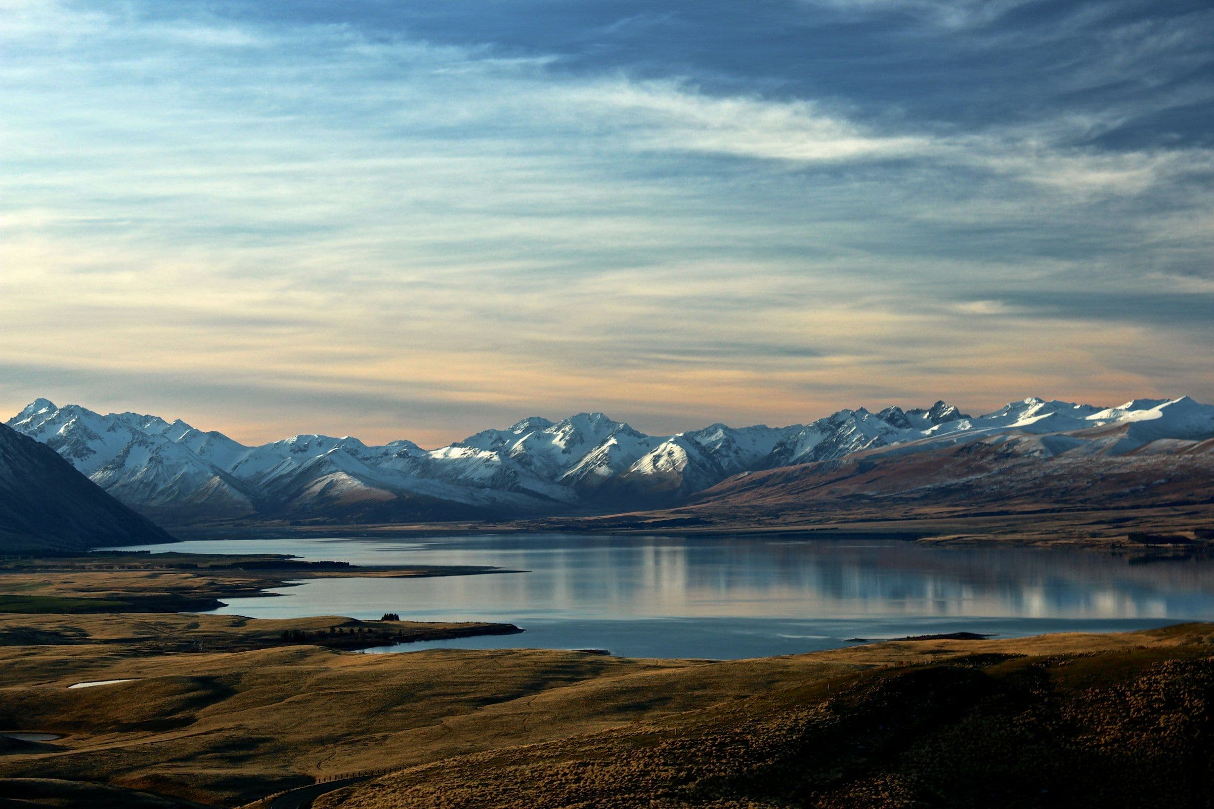 Cool panorama of a mountain lake beneath a long snow range
