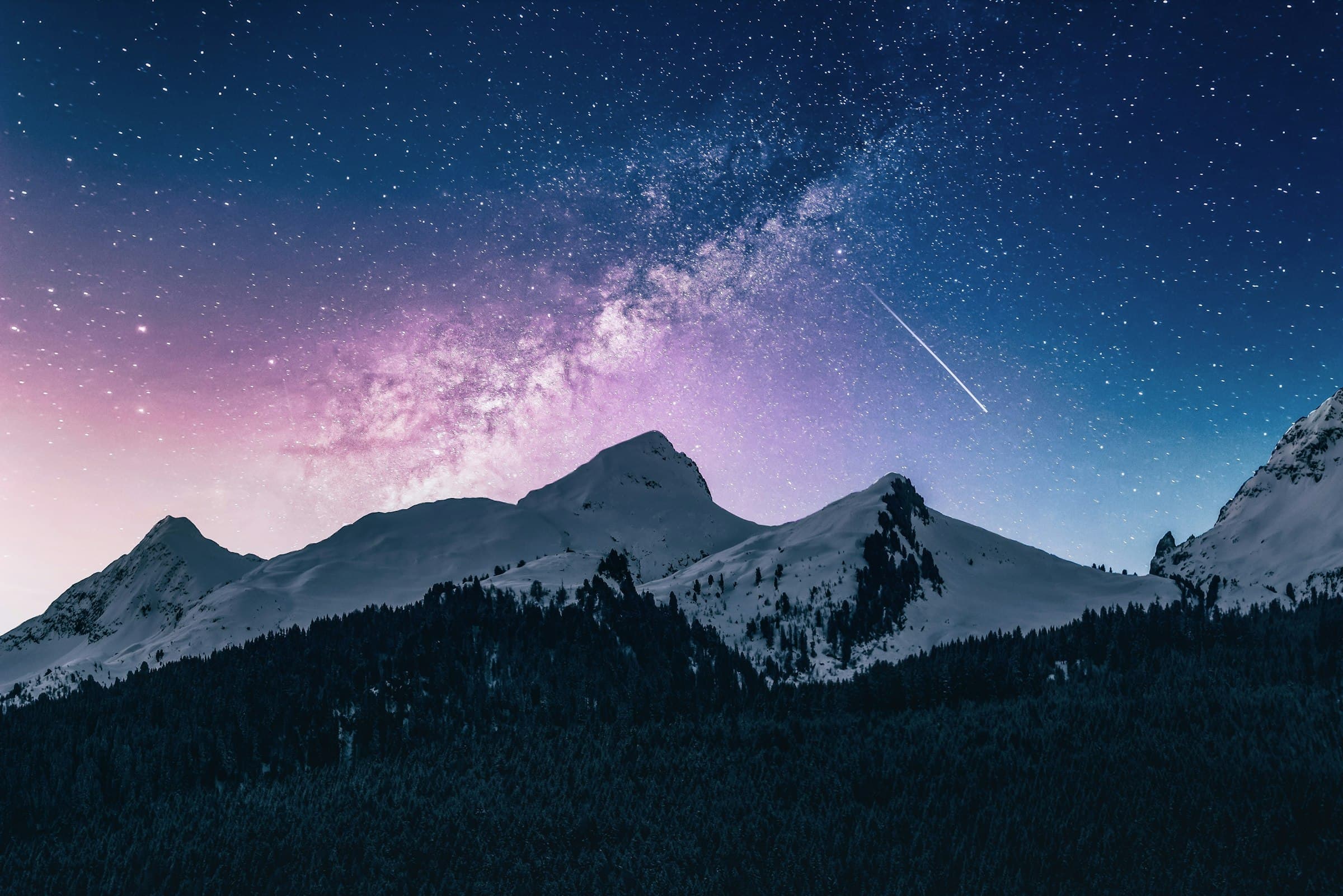 Snowbound peaks under a star-filled night sky